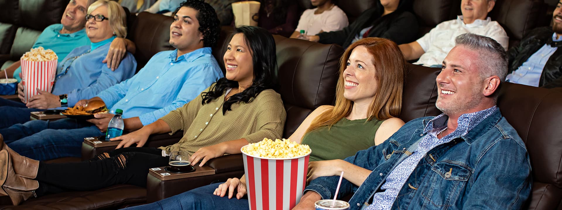 Guests enjoying movies in plush recliners at Crowne Pointe Theatre